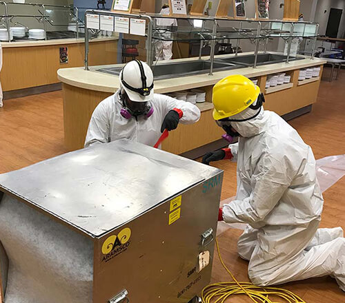 ServiceMaster Recovery Management employees wearing protective gear and restoring a cafeteria