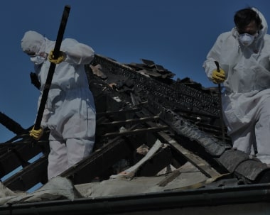 ServiceMaster Recovery Management employees in protective gear restoring a burnt structure